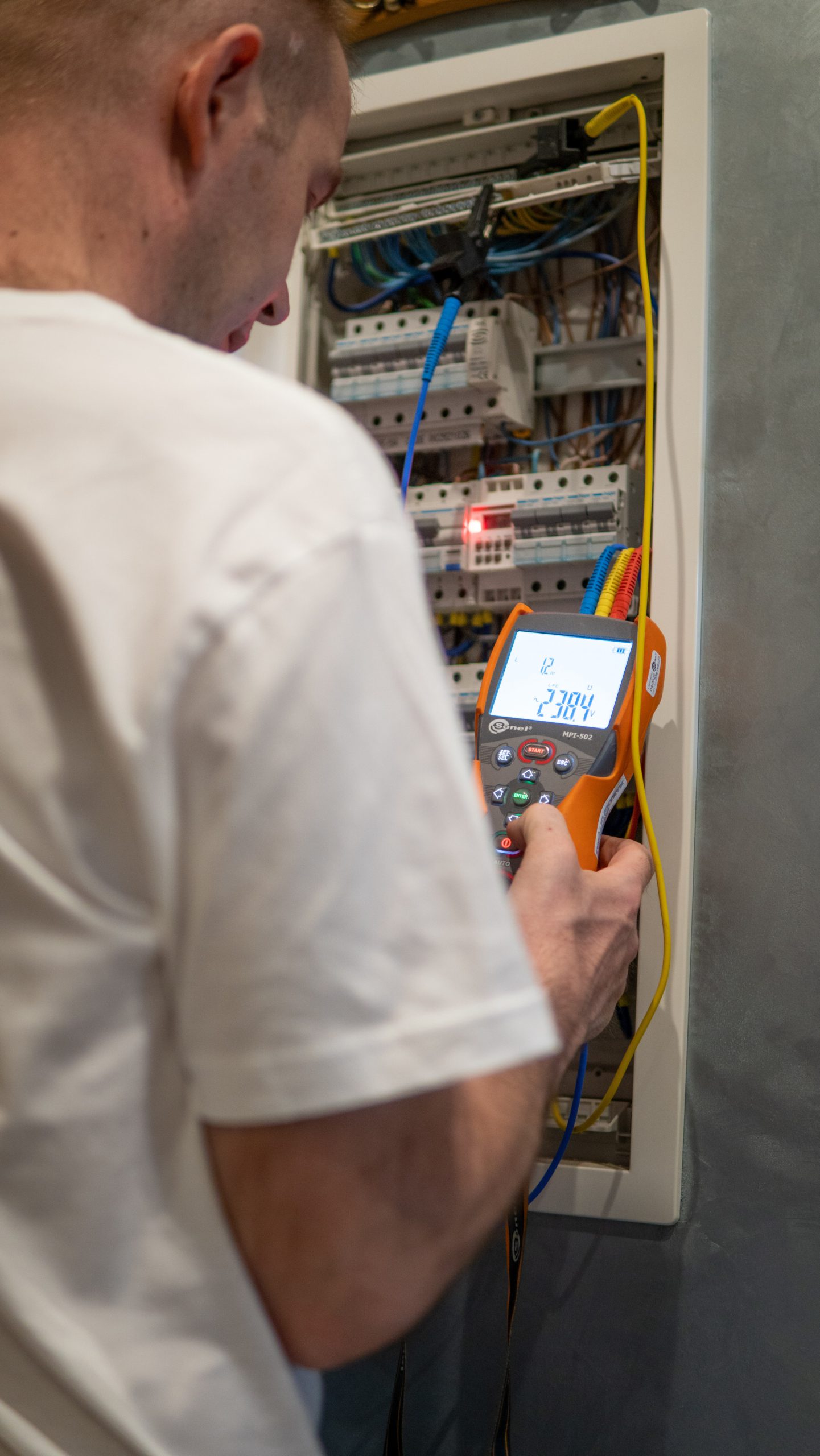 elektryk wykonuje pomiary elektryczne